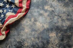 Tattered American flag displaying faded stars and worn fabric against a dark background photo
