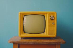 A vintage yellow television sits on a wooden table against a striking turquoise wall photo