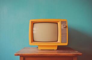 Retro yellow television set on a wooden table against a blue wall in a cozy indoor space photo