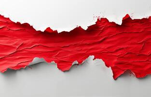 Frayed red paper tearing to reveal a white background with splattered paint effects photo