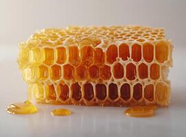 Fresh honeycomb and dripping honey displayed on a clean surface showcasing natural sweetness photo