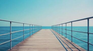 Wooden pier extending over calm blue waters on a clear sunny day photo