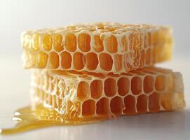 Freshly harvested honeycomb drizzled with golden honey on a clean white surface photo