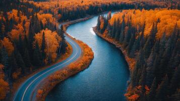 Curving road through vibrant autumn foliage at sunset in a mountainous landscape photo