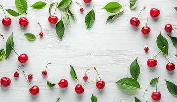 Fresh red cherries and green leaves scattered on a rustic white wooden background photo