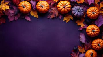 Colorful autumn pumpkins and leaves arranged on a purple background for seasonal decoration photo