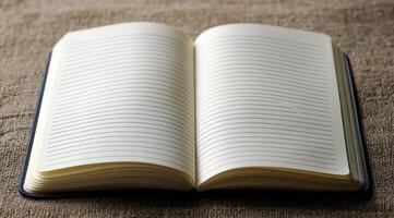 A blank notebook lies open on a blue surface, inviting creativity and ideas to flow freely photo