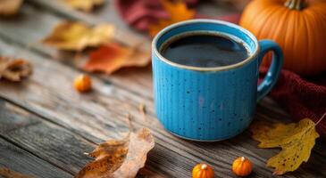 Cozy autumn morning with a blue mug of coffee surrounded by pumpkins and colorful leaves photo