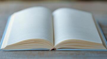 A blank notebook lies open on a blue surface, inviting creativity and ideas to flow freely photo
