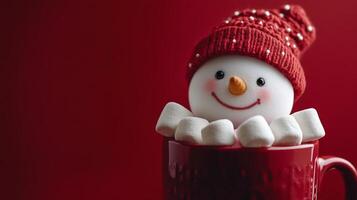 A cheerful snowman nestled in a red mug surrounded by marshmallows during winter festivities photo