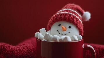A cheerful snowman nestled in a red mug surrounded by marshmallows during winter festivities photo