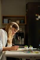 Person is sketching in notebook while working remotely at desk with laptop. Freelance work at home office. Graphic designer drawing sketch photo