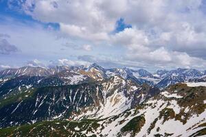 Panoramic view of snow-capped mountain range against cloudy sky. Tatra mountains in Zakopane, Poland. Giewont mountain summit. Natural landscape photo