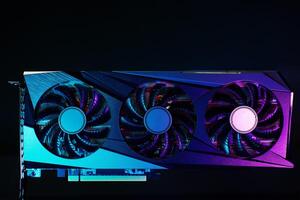 Close-up of high-performance graphics card with three cooling fans with neon lighting. Modern card for gaming and advanced computing photo