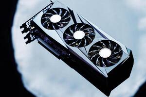 Close-up of high-performance graphics card with three cooling fans on dark background. Modern card for gaming and advanced computing photo