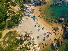 Aerial drone top view of ocean's beautiful waves crashing on the rocky island coast at Ke Ga beach in Mui Ne, Phan Thiet, Binh Thuan, Vietnam. Selective focus. Travel concept. photo