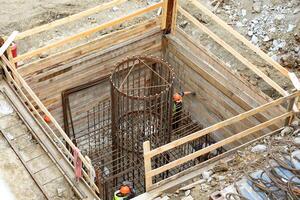 Construction site. Workers making a formwork for a concrete column photo