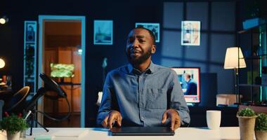 African american content creator filming technology review of newly released laptop, unboxing it and presenting specs to audience. Influencer showing ultra slim notebook to viewers photo