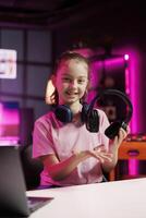 Gen Z technology internet star filming headphones review, comparing maximum volume on both pairs. Happy girl showcasing audio devices to audience, drawing sound quality parallels between products photo