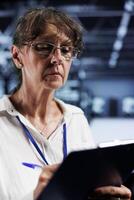 Senior proficient worker inside high tech establishment providing computing resources needed for AI to process extensive datasets for training. Blade servers storing data used for machine learning photo
