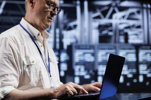 Octogenarian system administrator in data center providing dedicated VPN servers able to deliver enhanced privacy, encrypted sensitive data, online anonymity and stable internet connections to users photo