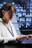 Overseeing supervisor preparing server rows contingency plan, monitoring data center energy consumption across parts, making sure sensors are functioning seamlessly, doing routine disk checks photo