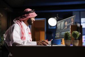 Male cinematographer editing new project, creating film montage, and working with footage and sound. Detailed shot shows a man using post-production software to process a movie on a computer. photo