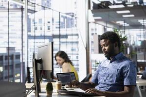 System administrator conducting detailed code review to fix bugs, identifying potential performance and technical issues with company software. African american man debugging and optimizing code photo