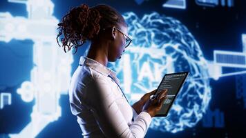 IT specialist updating AI systems, writing intricate binary code scripts on tablet, visualizing result wth AR. Licensed employee using programming to upgrade artificial intelligence simulation model photo