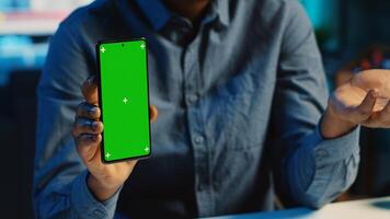 Content creator films chroma key smartphone review for tech enthusiasts, close up. Viral online star hosts technology internet show, unboxing isolated screen cellphone, focus on product photo