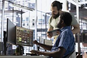 Team of technicians creating machine learning models that can process and analyze data to improve and automate decision making processes. IT worker and colleague programming in office photo