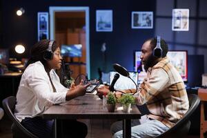 Woman radio show host having conversation with man, recording program for audience listening live. Presenter engrossed in a chat with blogger, broadcasting podcast episode for fans. photo