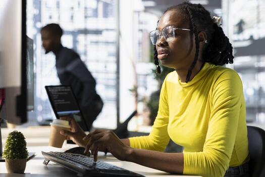 Office clerk looking at computer monitor, checking key data needed for finding business insights and finishing project task. African american woman analyzing data on computer photo