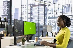 Admin looking at isolated screen computer, managing cloud computing resources and platforms to train machine learning models. Woman monitoring and maintaining company systems using chroma key PC photo