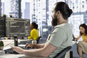 Computer scientist testing and debugging company software to minimize occurrence of bugs, identifying bottlenecks. IT expert in office writing clean code in programming language to reduce errors photo