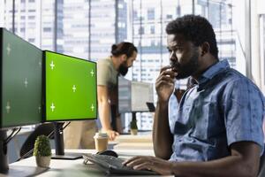 Man checking paperwork details on chroma key PC screen, solving tasks. Worker in office making sure documents are compliant with quality assurance standards using isolated screen computer photo