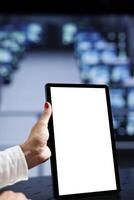 Close up shot of mock up tablet used by certified IT specialist in data center using server clusters to deliver massive computing power, control network resources, process and store datasets photo