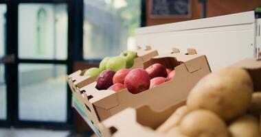 Natural ripe colorful apples in crates at local organic eco store, fruits and vegetables on farmers market shelves. Freshly harvested chemicals free items grown in environmentally friendly spaces. photo