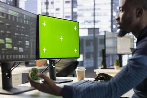 Admin using chroma key PC to develop machine learning APIs solving complex problems. IT specialist training predictive models capable of handling complex tasks using green screen computer photo