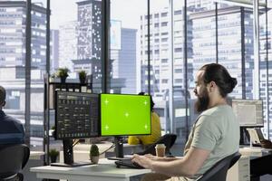 Admin using mockup computer, testing machine learning company software to minimize occurrence of bugs, identifying bottlenecks. Man writing clean, efficient code on green screen PC to reduce errors photo