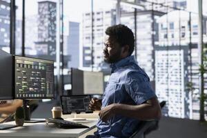 Programmer in pain, suffering muscle sprain while developing machine learning APIs solving complex problems. Man feeling backache from sitting on desk chair while training predictive models photo