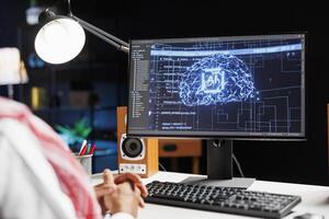 Arabian professional monitoring a futuristic network, ensuring cybersecurity. Expert in artificial intelligence and machine learning, he utilizes a supercomputer for efficient data management. photo