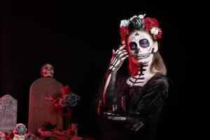 Portrait of woman participating in Day of the Dead Mexican event honoring dead loved ones, building ofrendas for them. Person doing ancient Aztec custom of celebrating ancestors, wearing flower wreath photo