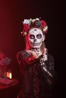 Woman doing enticing invitation hand gesture at Day of the Dead event to remember the deceased. Lady doing seducing wooing gesturing during Mexican holiday of remembrance for those who have passed photo
