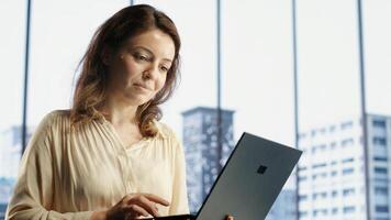 Female CEO leader working on financial planning and budget allocation, ensuring the company resources are used effectively to achieve maximum profit and long term objectives in office. Camera B. photo