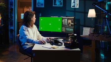 editor using editing software on green screen monitor to upgrade footage shot, commissioned by production teams outsourcing tasks. Freelancer videographer finishes project on mockup PC, camera B photo