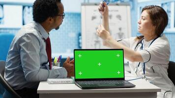 Doctor meeting with a patient in medical office next to copy space on display, employing medical technology at the hospital. Specialist physician helping a man with disease at check up. Camera A. photo