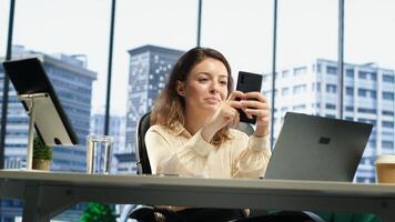 Business director texting messages and discussing about enterprise performance, sharing insight on updates and details. Young entrepreneur using her personal phone on social media. Camera A. photo