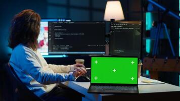Admin using green screen laptop to implement security measures, protecting company systems and data. IT worker testing and debugging code for software applications on chroma key notebook, camera A photo