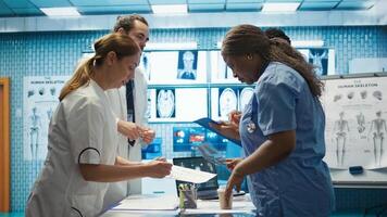 Team of specialists reviewing ecg results in a meeting at a private clinic, analyzing cardiovascular system on a radiography for disease prevention. Consulting scans and records. Camera B. photo